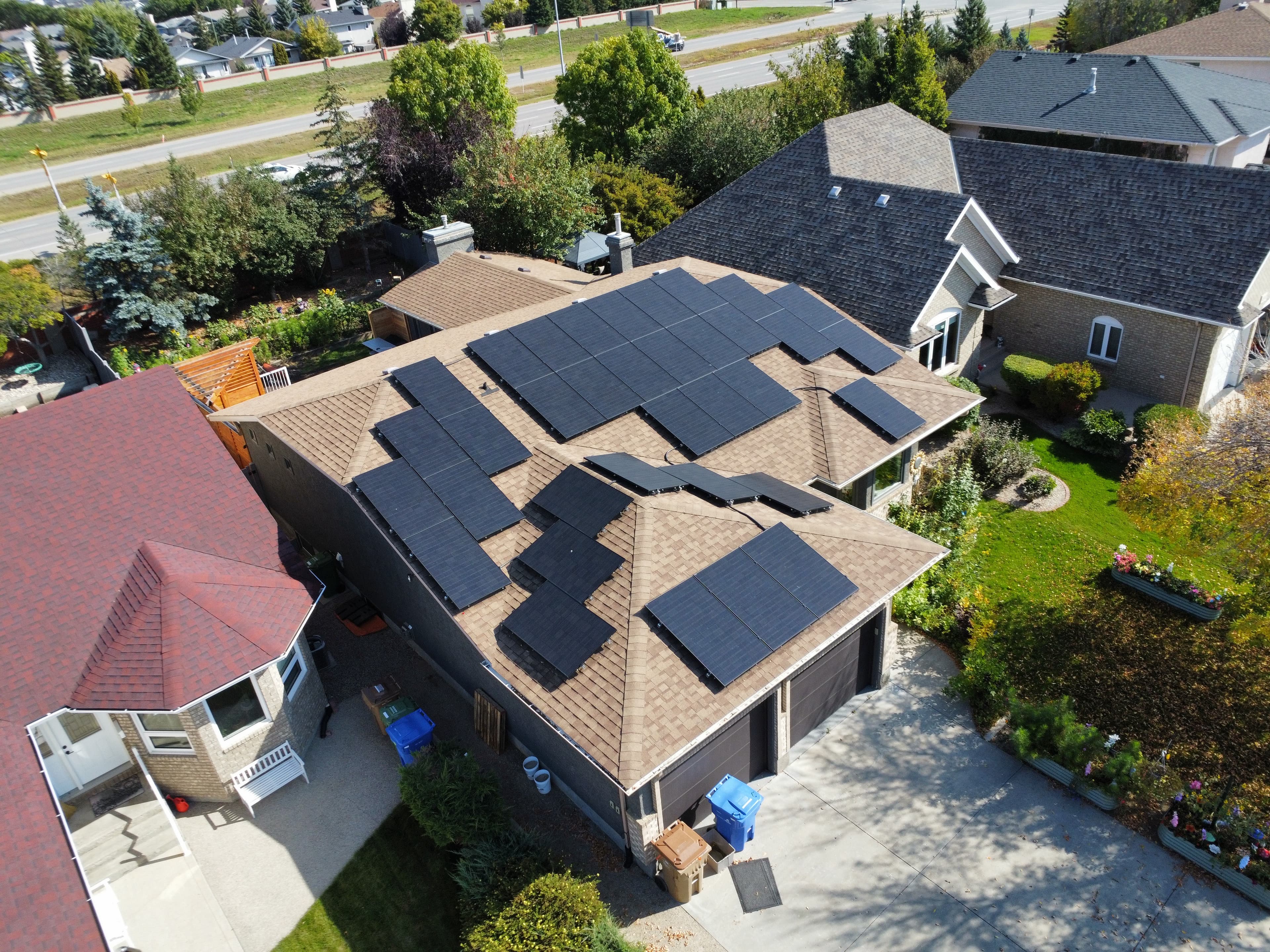 Aerial view of an all-black rooftop solar array filling both roof planes of a Saskatchewan home, installed by Prairie Sun Solar
